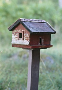 A detail of a rustic, wooden bird house,